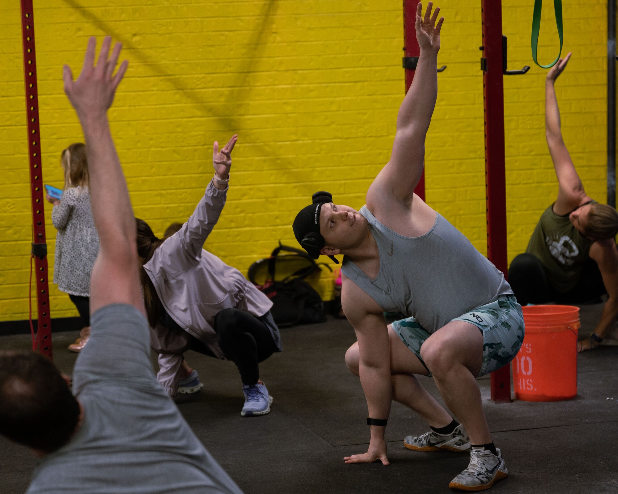 U.S. Air Force Master Sgt. Dalton Grainger, 316th Training Squadron instructor, stretches with his fitness class to begin their workout at his local gym, San Angelo, Texas, January 12, 2022. Grainger recently accomplished his goal of joining the 1,000 lbs. club, a term used for competition powerlifters that move over 1,000 lbs. cumulatively over the three main events; squat, deadlift, and bench press. (U.S. Air Force photo by Senior Airman Michael Bowman)