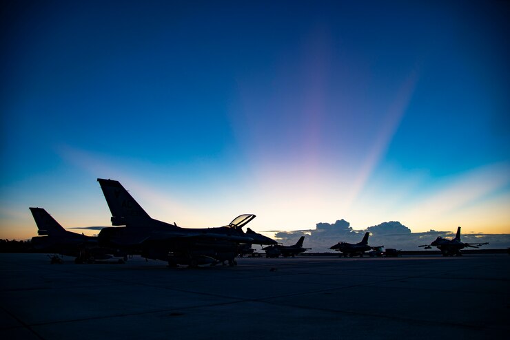 U.S. Air Force F-16C Fighting Falcons, from the 177th Fighter Wing of the New Jersey Air National Guard, are illuminated by morning sunlight on the flight line at Boca Chica Naval Air Station, Fla. Jan. 12, 2022.