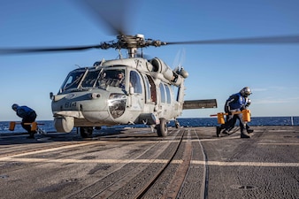 Sailors chock and chain an MH 60S Sea Hawk Helicopter assigned to the "Proud Warriors" of Helicopter Maritime Strike Squadron (HSM) 72 on the flight deck of the Ticonderoga-class guided-missile cruiser USS San Jacinto (CG 56).