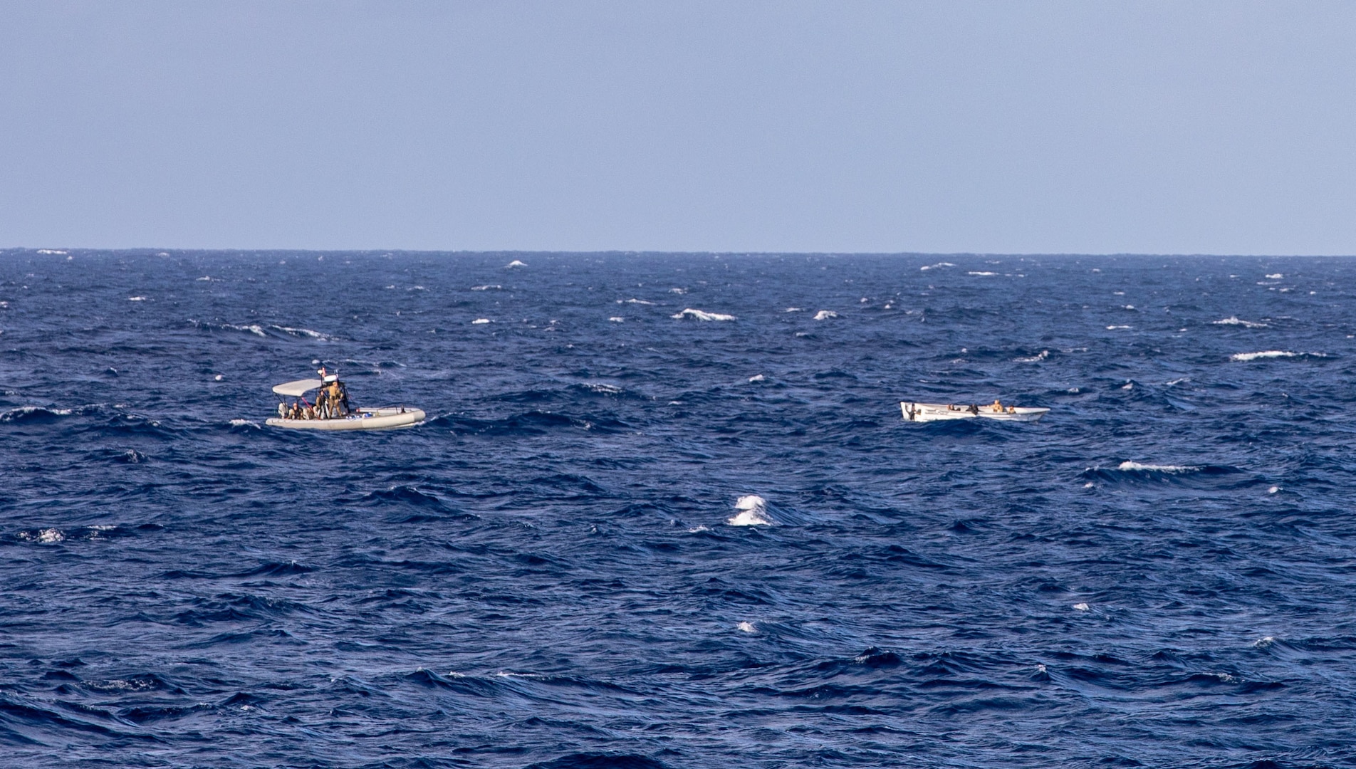 U.S. Navy Sailors on a small boat wait on scene with a suspected drug smuggling go-fast vessel (GFV) during a drug interdiction operation, Jan. 7, 2021.