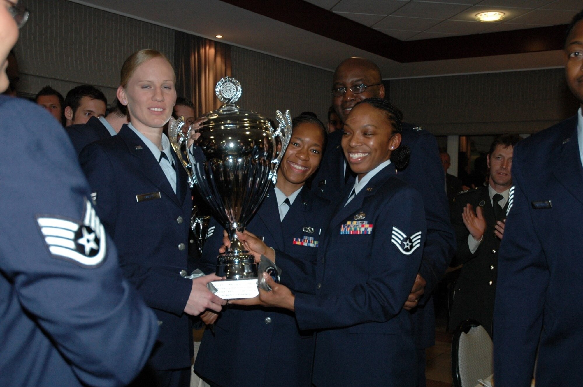 A photo of an Airman receiving a trophy