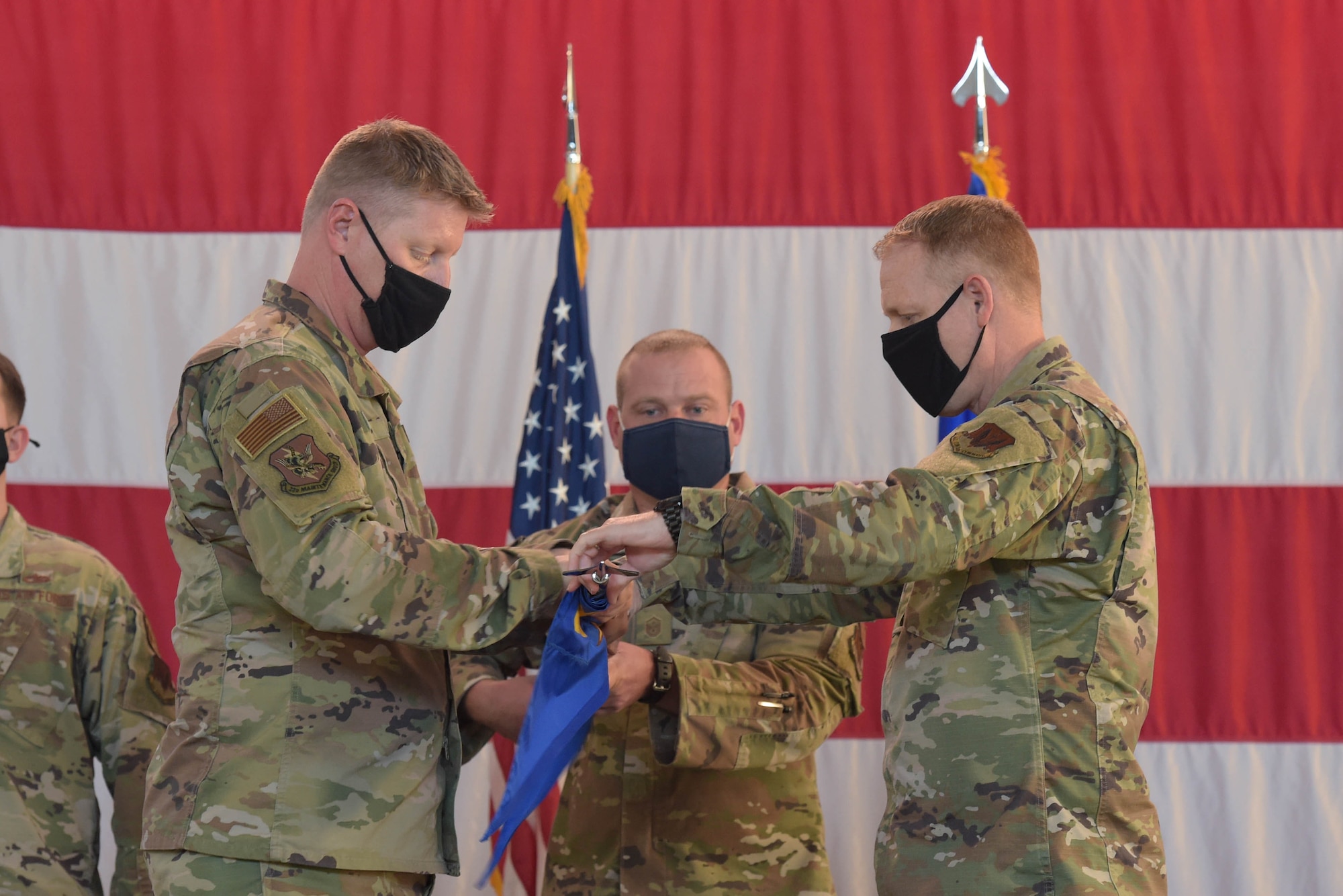 two men rolling a flag