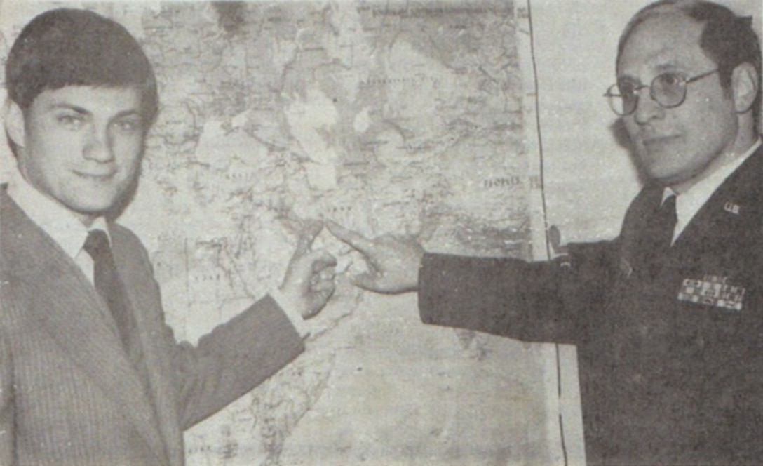 In a photograph taken in late 1979, OSI Special Agents Warren L. Smith (left) and Robert A. Hoffmann point to a map marking the location of Isfahan, Iran. (U.S. Air Force photo)
