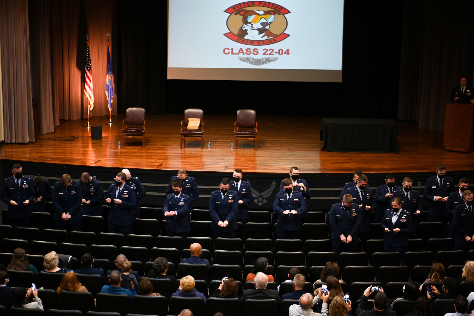 Specialized Undergraduate Pilot Training Class 22-04 break their pilot wings at their graduation on Jan. 14, 2022, at Columbus Air Force Base, Miss. As tradition, new pilots break their first pair of pilot wings in half, keeping one half and giving the other half to a loved one. (U.S. Air Force photo by Senior Airman Davis Donaldson)