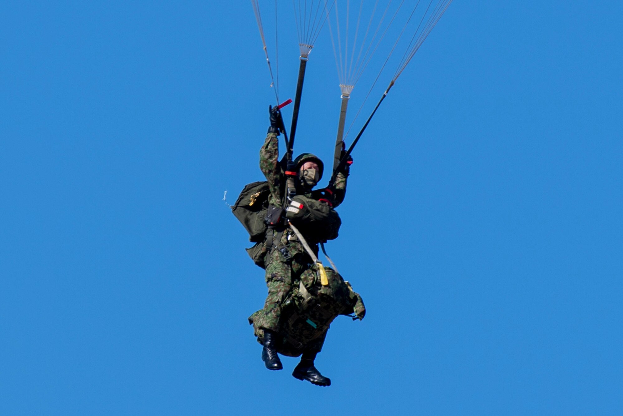 A Japan Ground Self-Defense Force paratrooper from the 1st Airborne Brigade, adjusts his parachute above a drop zone