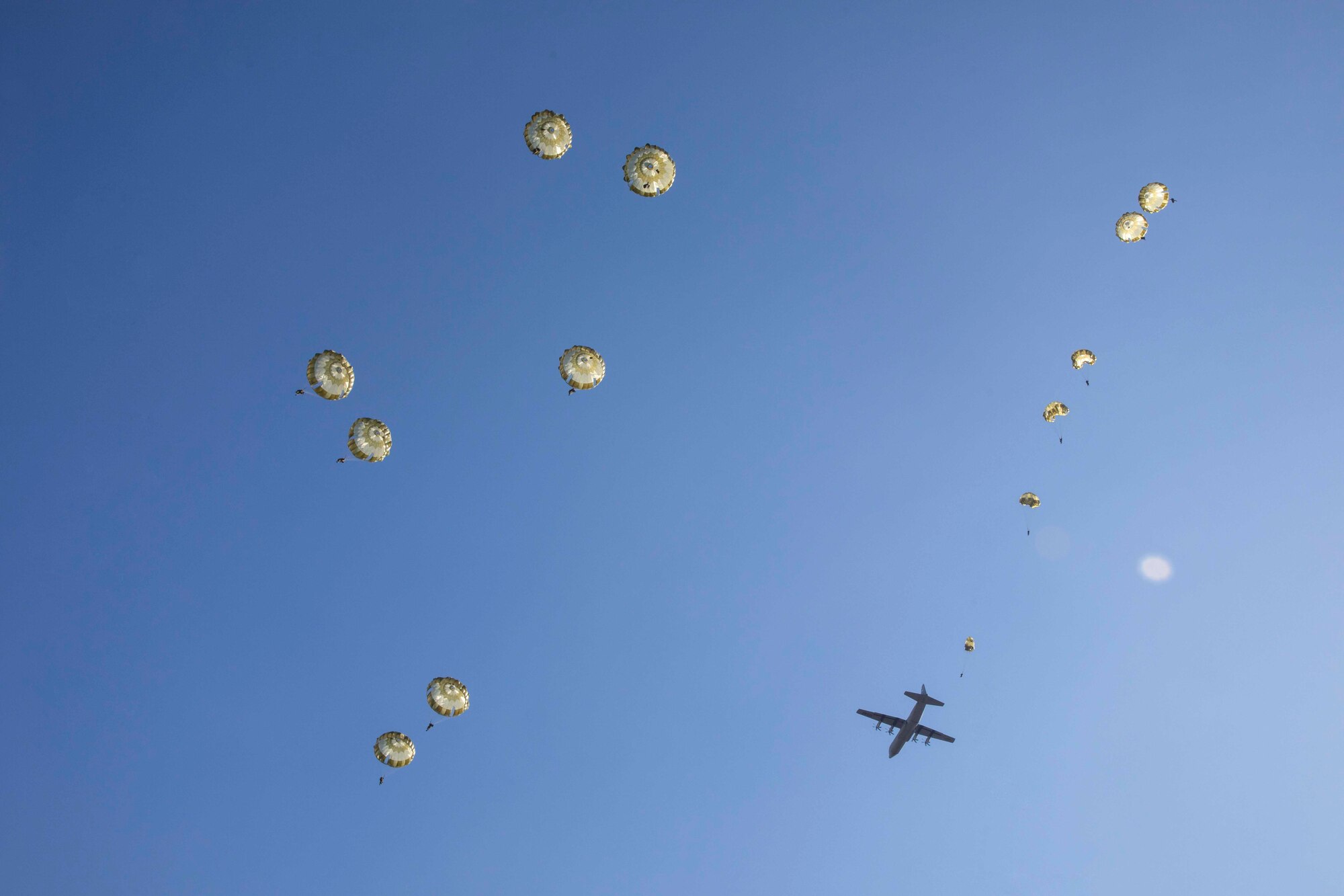 Paratroopers deploying parachutes