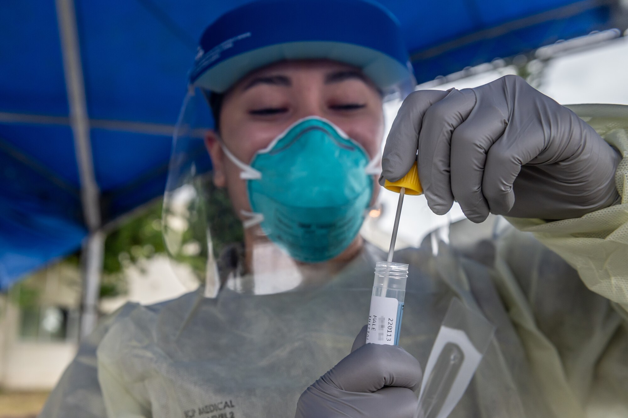 Airman placing test swab into a tube