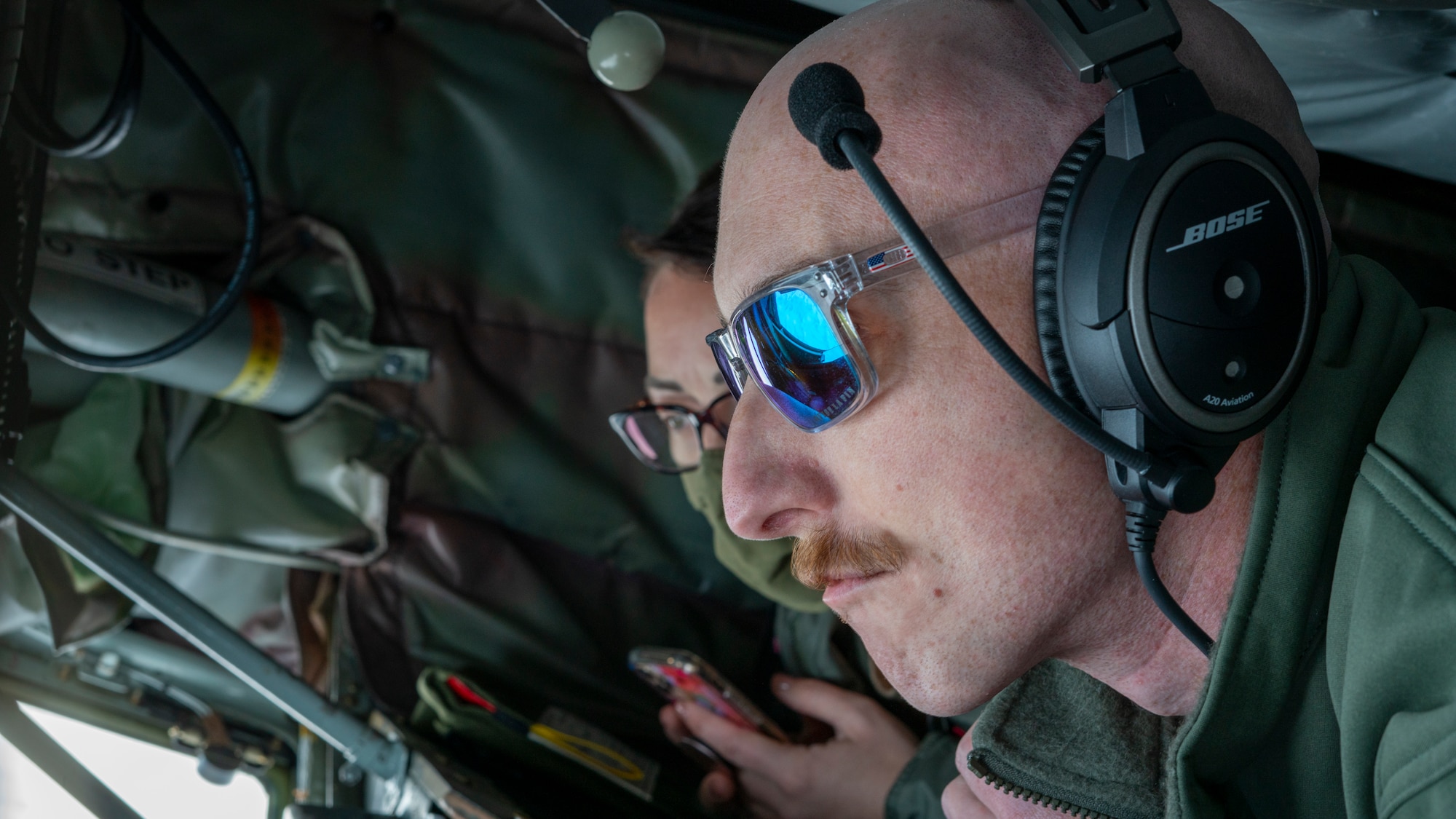 Staff Sgt. James Kennedy, 909th Air Refueling Squadron instructor boom operator, stares out the window as he prepares to make contact with a receiver aircraft over the Pacific Ocean