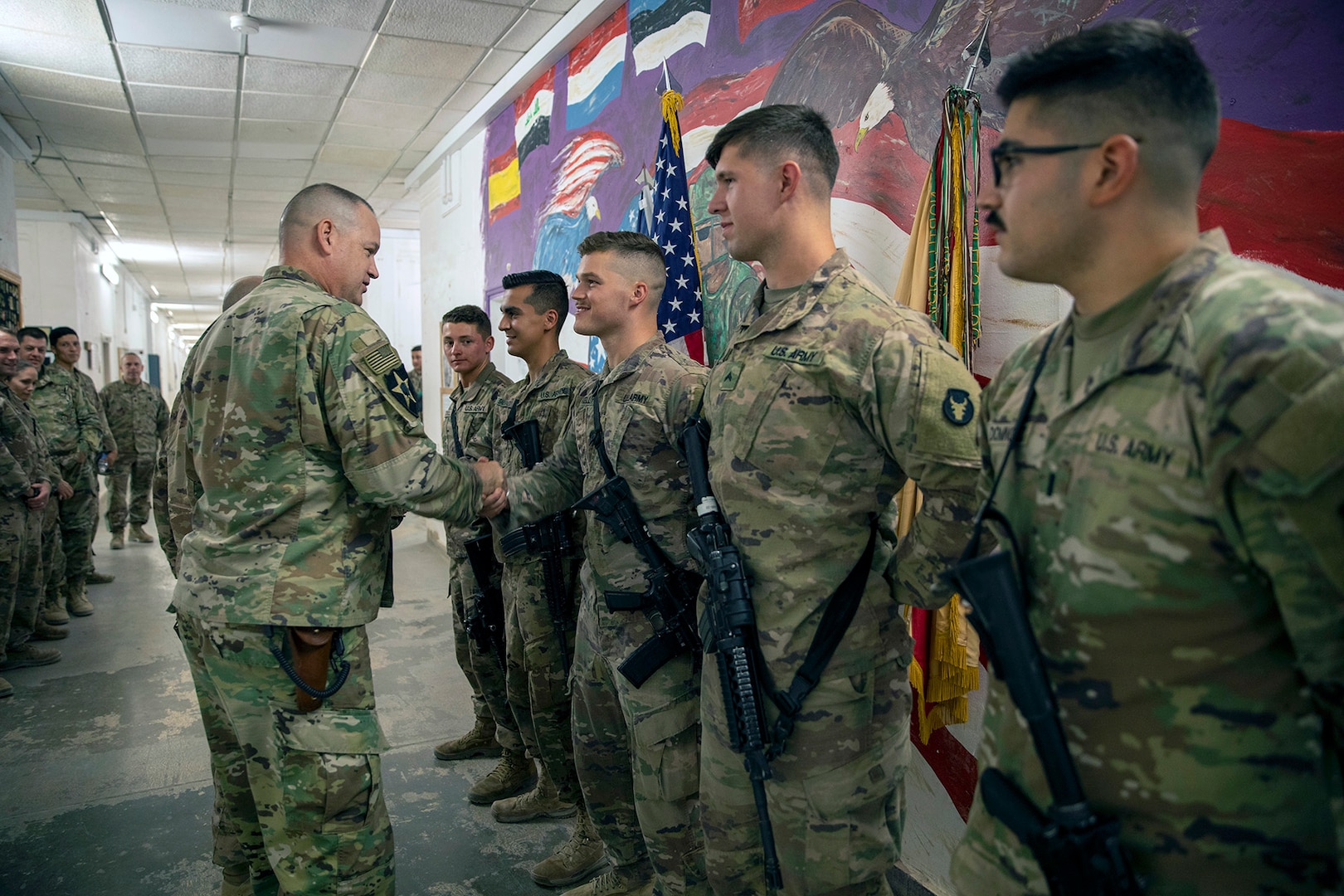 U.S. Army Spc. Kristian Kelly, a small arms artillery repair specialist, is recognized with fellow Soldiers, all from the 1st Battalion, 194th Field Artillery, for their support in defending the base from enemy rockets and unmanned aerial vehicles by Al Asad Air Base commander Col. Mark Coble, 734th Regional Support Group, at Al Asad Air Base, Iraq, on June 12, 2021. The Iraqi-owned base houses Coalition forces, and was a target of multiple attacks between March and July 2021. (U.S. Army photo by Cpl. Jacob Gleich)