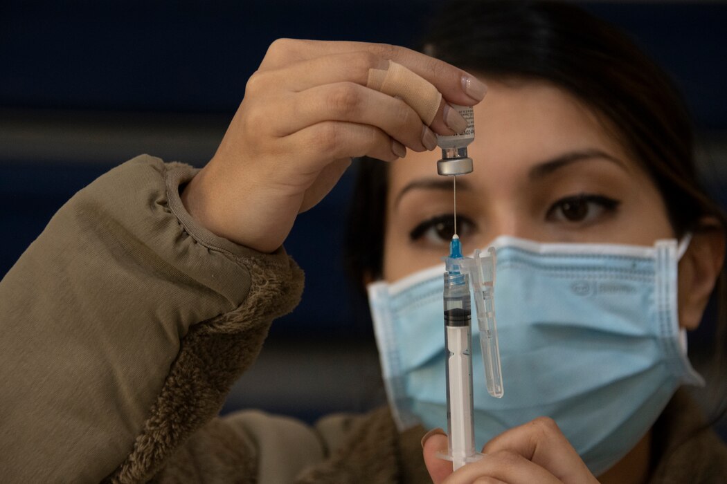 Airman assigned to the 307th Medical Squadron prepares a syringe before administering a COVID-19 vaccination at Barksdale Air Force Base
