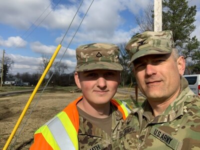 Col. Tim Starke, director of operations for the Kentucky National Guard, with Pfc. Cody Warmath in Cayce, Ky., where Warmath was helping clean up after tornadoes tore through the area Dec. 10, 2021. Warmath's family's home suffered severe damage during the storm but he still chose to volunteer to be activated with the 2113th Transportation Company out of Paducah, Ky.
