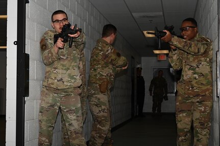 U.S. Air Force Staff Sgt. Robert Ferry, U.S Air Force Tech. Sgt. Christian Kampe and U.S. Air Force Tech. Sgt. La Donna Winston, assigned to the 11th Security Forces Squadron on Joint Base Anacostia-Bolling, prepare to clear a room during a training event at the Metropolitan Police Academy, Washington, D.C., Nov. 24, 2021. During the training, participants conducted building searches, room clearing and tactical team movements. Participating in these training opportunities prepares the JBAB team to enable joint, interagency and community missions. (U.S. Air Force photo by Airman 1st Class Anna Smith)