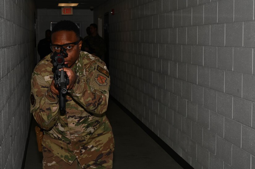 U.S. Air Force Tech. Sgt. La Donna Winston, assigned to the 11th Security Forces Squadron on Joint Base Anacostia-Bolling, stands watch while her partner clears a room during a training event at the Metropolitan Police Academy, Washington, D.C., Nov. 24, 2021. Winston participated in the direct-to-threat portion of the training event that included fast-paced tactical team movements to assess known and unknown threats. During the training, participants conducted building searches, room clearing and tactical team movements. Participating in these training opportunities prepares the JBAB team to enable joint, interagency and community missions. (U.S. Air Force photo by Airman 1st Class Anna Smith)