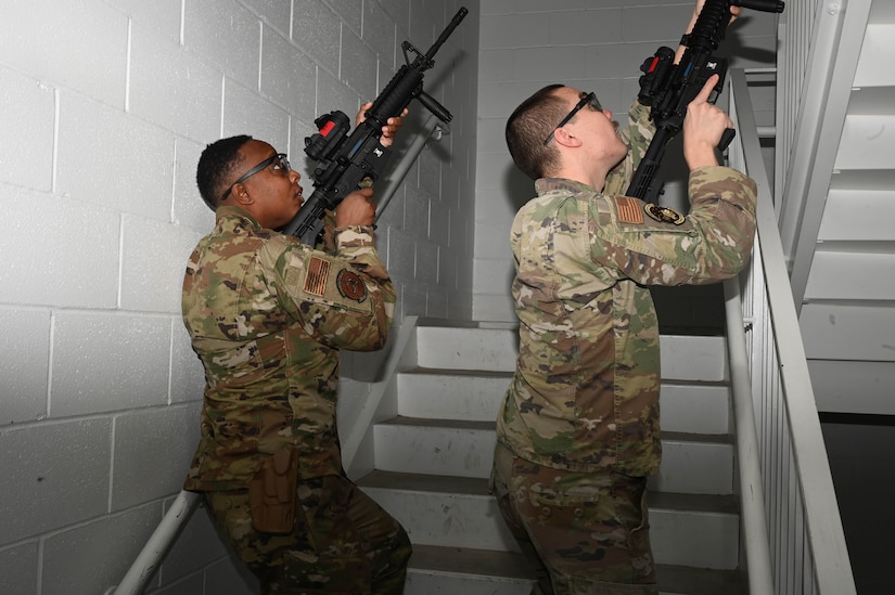 U.S. Air Force Tech. Sgt. La Donna Winston and U.S. Air Force Staff Sgt. Robert Ferry, assigned to the 11th Security Forces Squadron on Joint Base Anacostia-Bolling, participate in a training event at the Metropolitan Police Academy, Washington, D.C., Nov. 24, 2021. Winston and Ferry practiced securing a stairwell during one phase of the training. During the training, participants conducted building searches, room clearing and tactical team movements. Participating in these training opportunities prepares the JBAB team to enable joint, interagency and community missions. (U.S. Air Force photo by Airman 1st Class Anna Smith)
