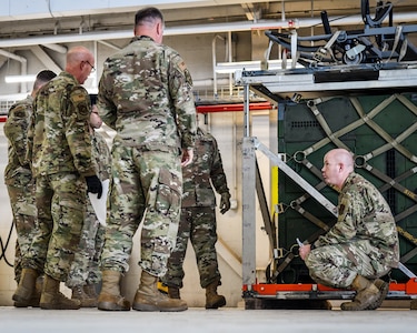 Members of the 147th Attack Wing test a vertical pallet stacking system at Ellington Field JRB, Houston, Texas, Jan. 5, 2022. The Wing is partnering with Air Force Research Laboratories, USTRANSOM and the University of Ohio at Dayton to test the innovative technology that allows for cargo pallets to be stacked on top of each other, enabling cargo aircraft to carry more.