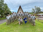 The Civic Action Team- Palau stand in front of their camp for a photo. The CAT is a tri-service deployment to Palau that has been running for over 50 years. The team is from the 36th Civil Engineering Squadron and they have 6 main objectives; Community Construction Projects, Community Relations Projects, Monument Maintenance, Apprenticeship Program, Medical Care and Camp Maintenance.