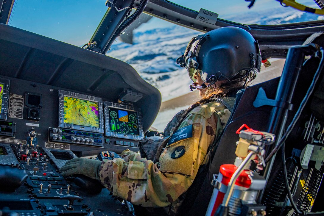 A soldier in the cockpit of an airborne aircraft.