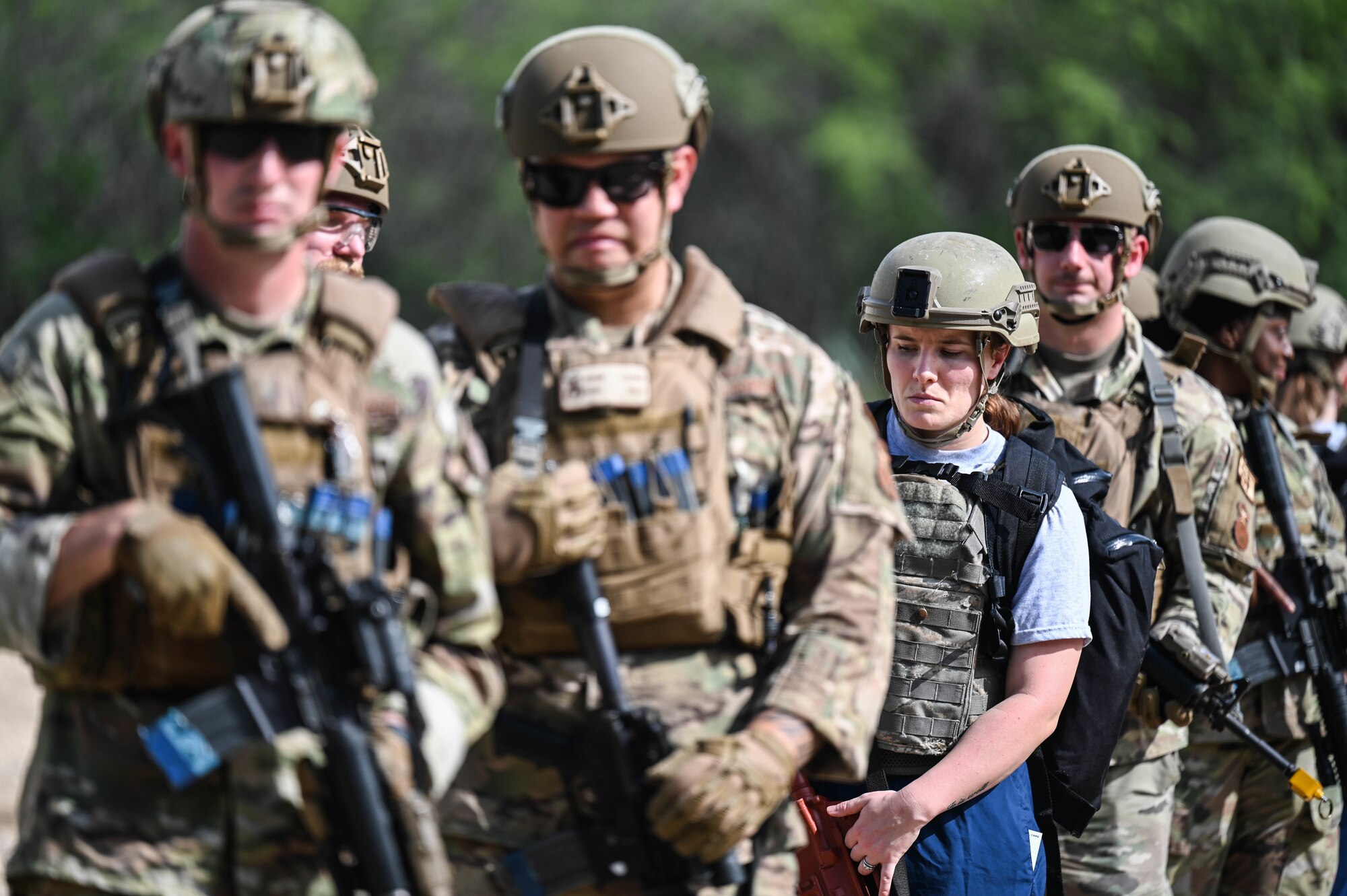 Senior Airman Kathryn Cornelius, 15th Operational Medical Readiness Squadron aerospace medical technician, stands in a line-formation with members from the 647th Security Forces Squadron during a joint field training exercise at Joint Base Pearl Harbor-Hickam, Hawaii, Jan. 12, 2022. Medical operations performed during this training are mandated by the Department of Defense for every tier III medic. (U.S. Air Force photo by Staff Sgt. Alan Ricker)