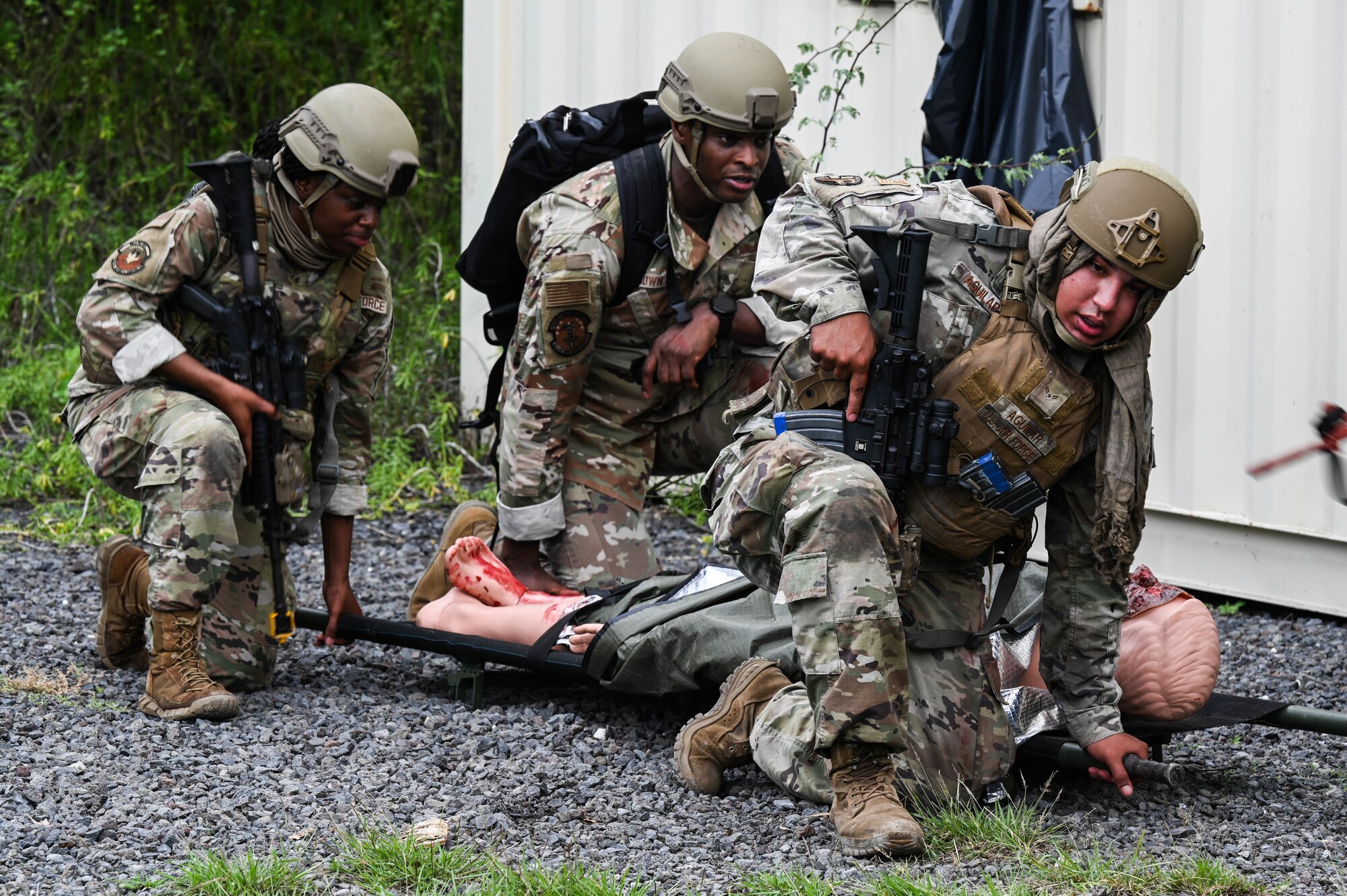 Airmen from the 647th Security Forces Squadron and the 15th Medical Group perform a litter carry during a joint field training exercise at Joint Base Pearl Harbor-Hickam, Hawaii, Jan. 12, 2022. A volunteer participated in moulage and two additional human patient manikins were implanted in the exercise to provide realistic combat scenarios for medical personnel. (U.S. Air Force photo by Staff Sgt. Alan Ricker)