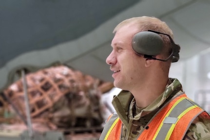 Alaska Air National Guard Staff Sgt. Brock Shope, 176th Logistics Readiness Squadron Air Terminal Function, helps to load cargo Jan. 12, 2022, on a 211th Rescue Squadron HC-130J Combat King II at Joint Base Elmendorf-Richardson, Alaska. The HC-130 was carrying 20 Alaska National Guard Soldiers and Airmen to Yakutat in response to a weather disaster. (U.S. Air Force courtesy photo by Master Sgt. Serjio Cerda)