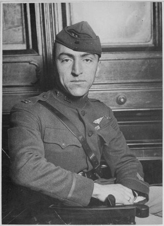 A soldier poses for a photo while seated in his uniform.