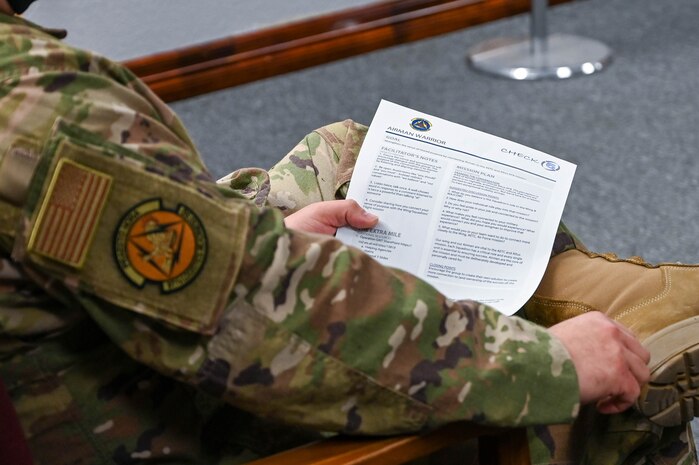 Master Sgt. Fernando Kemp, 97th Logistics Readiness Squadron (LRS) superintendent deployment and distribution flight, holds the Operation GRIT paper during a meeting at Altus Air Force Base, Oklahoma, Jan. 19, 2022. The 97th LRS was the first squadron to start Operation GRIT at AAFB. (U.S. Air Force photo by Senior Airman Kayla Christenson)