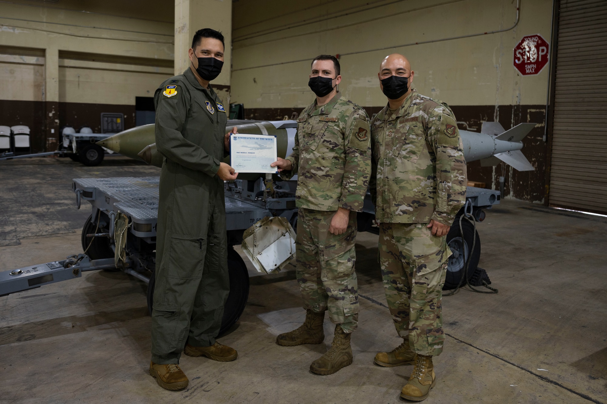 U.S. Air Force Staff Sgt. Derek Merkley, Munitions Support Equipment Management crew chief with the 36th Munitions Squadron, receives the Linebacker of the Week award from Col. David Aragon, 36th Wing vice commander, and Chief Master Sgt. John Payne, 36th Wing command chief at Andersen Air Force Base, Guam, Jan. 12, 2022.