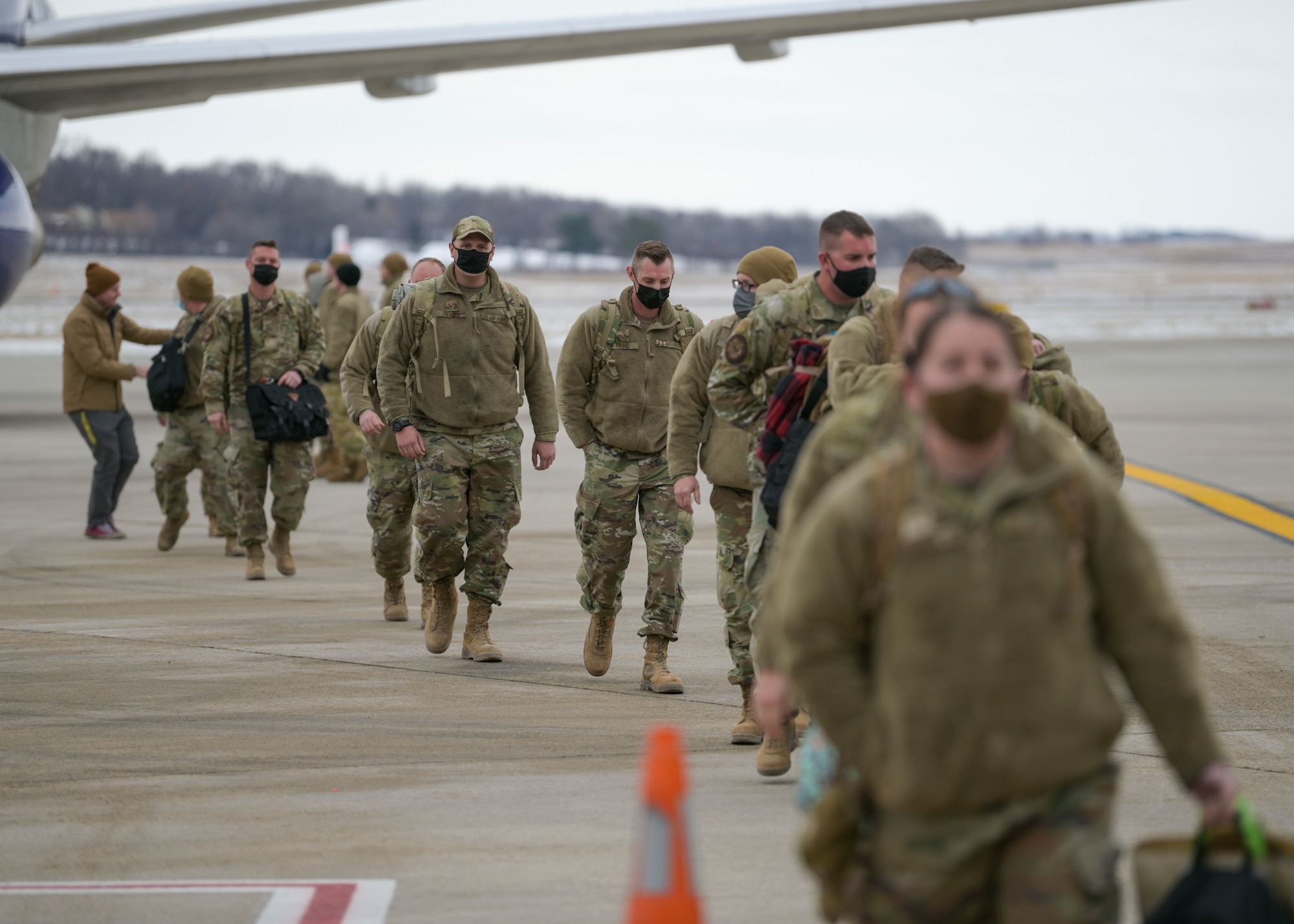 U.S. Air Force Airmen assigned to the 115th Fighter Wing and its active associate the 378th Fighter Squadron, Truax Field, Madison, Wisconsin take their first steps back on home soil Jan. 14, 2022. The Airmen were deployed to Prince Sultan Air Base, Saudi Arabia in support of U.S. Central Command Operations. (U.S. Air National Guard photo by Staff Sgt. Cameron Lewis)