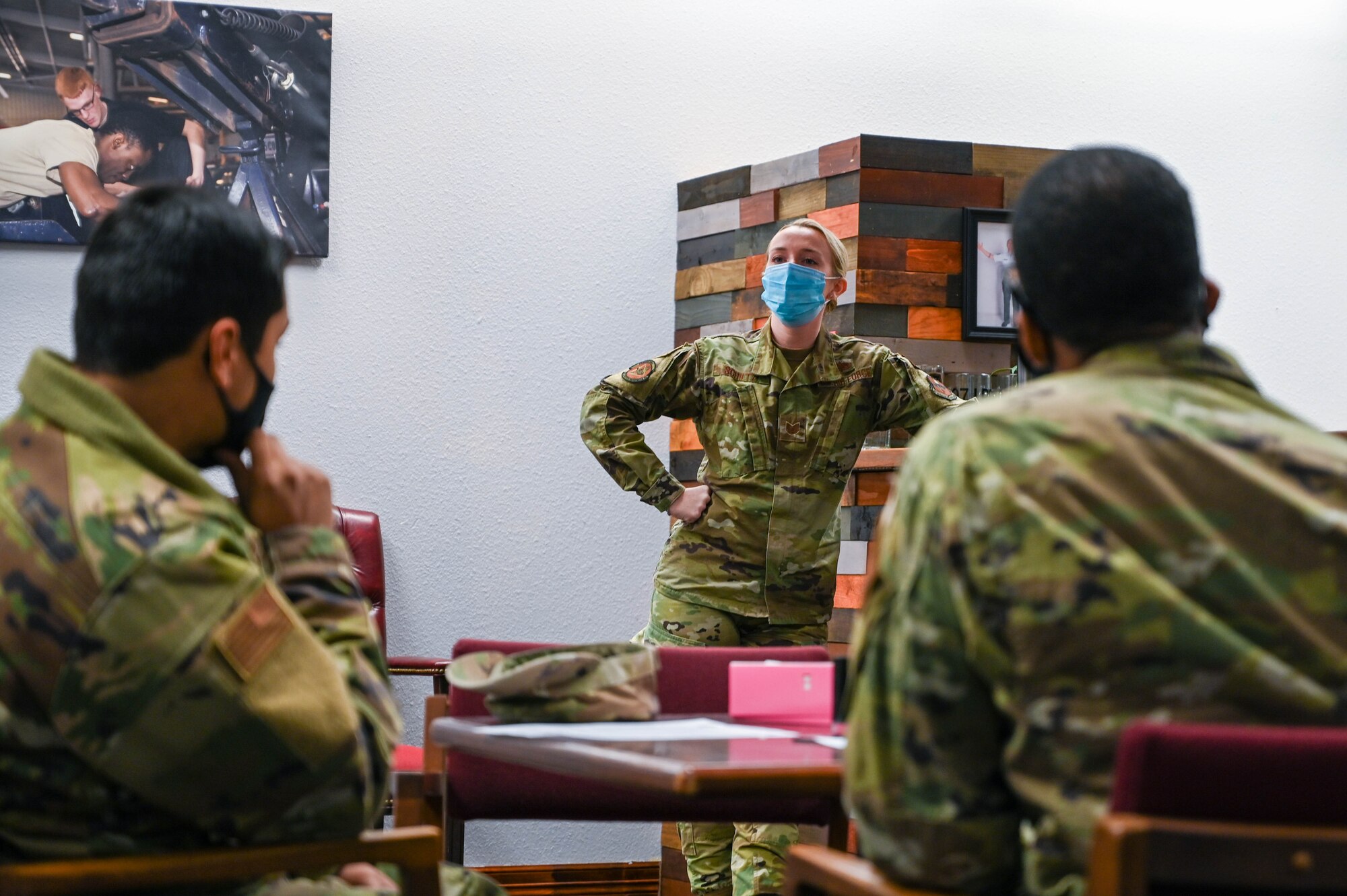 Airman 1st Class Jesus Bahena-Cortez (left), 97th Logistics Readiness Squadron (LRS) fuels distribution operator, and Staff Sgt. Aaron Canady (right), 97th LRS non-commissioned officer in charge training and support, listen to Tech. Sgt. Molly Shiltz, 97th LRS non-commissioned officer in charge of quality assurance, as she talks at an Operation GRIT meeting at Altus Air Force Base, Oklahoma, Jan. 19, 2022. January’s GRIT topic was the Airman warrior. (U.S. Air Force photo by Senior Airman Kayla Christenson)