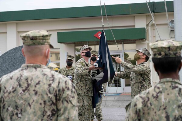 220118-N-PQ586-1002 OKINAWA, Japan (Jan. 18, 2022) Command Master Chief Martin Laurie (left), Naval Mobile Construction Battalion (NMCB) 5, hands the battalion flag to Utilitiesman 1st Class Sabino Martinez during a relief in place/transfer of authority (RIP/TOA) ceremony onboard Camp Shields in Okinawa, Jan. 18. This RIP/TOA marked the official completion of NMCB-5's deployment in the region. NMCB-5 is homeported in Port Hueneme, California. The Seabees will train on high-quality construction, expeditionary logistics, and combat operations during the homeport phase. They execute construction and engineering projects to support Major Combat Operations, disaster response, and humanitarian assistance. (U.S. Navy photo by Mass Communication Specialist 2nd Class Jessica Ann Hattell)