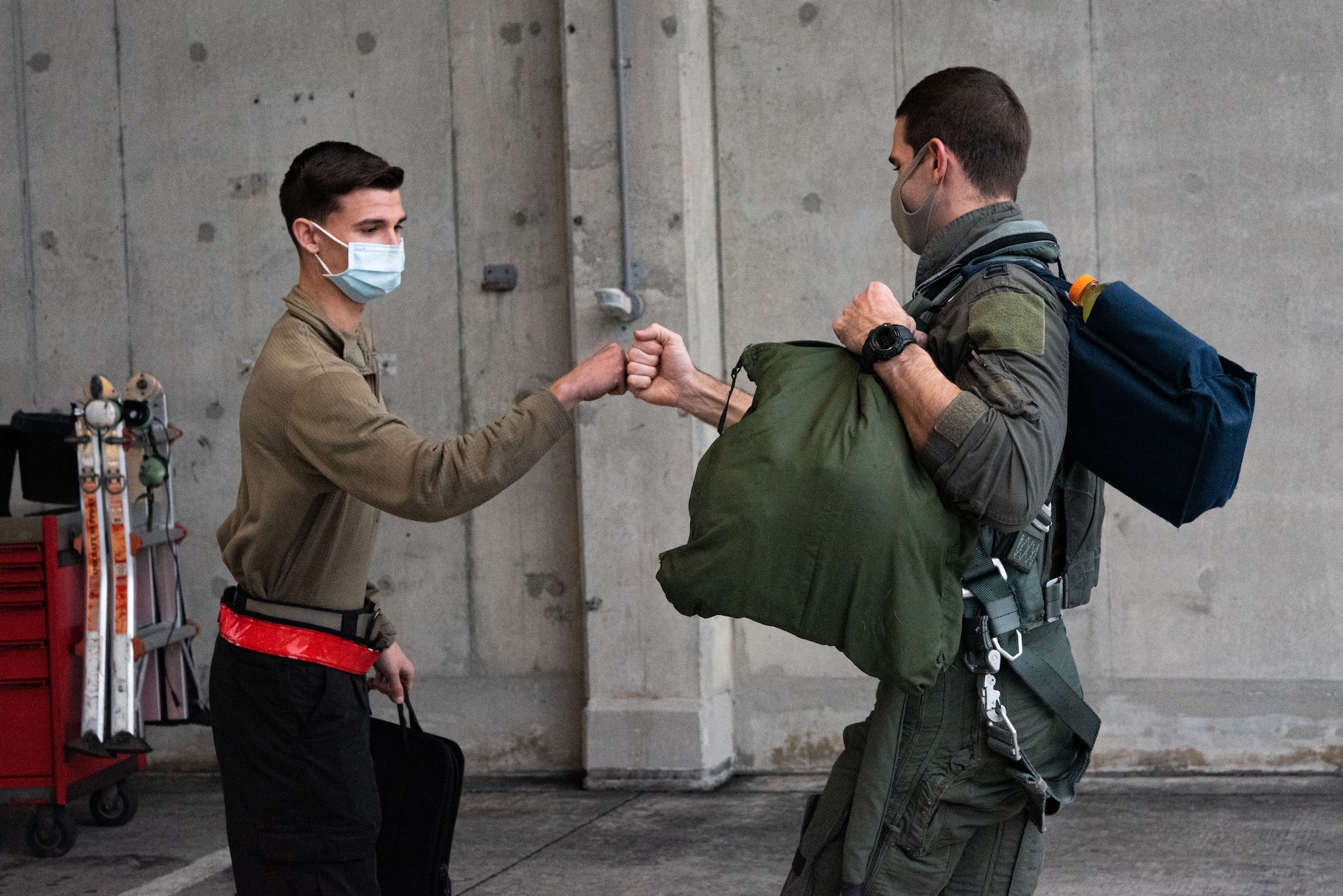 Airman and pilot fist bump before flight.