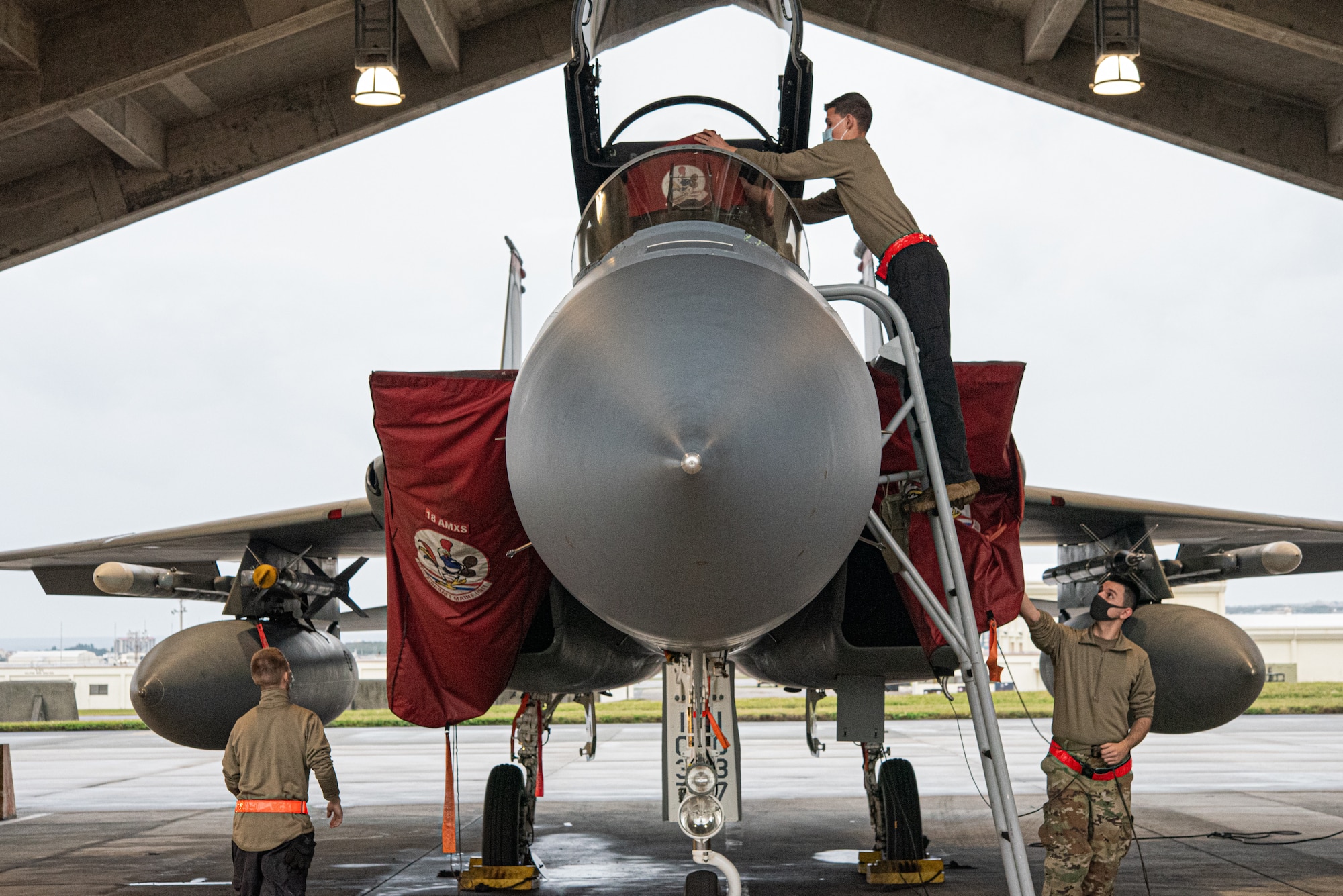 Airmen perform pre-flight checks on an F-15 Eagle
