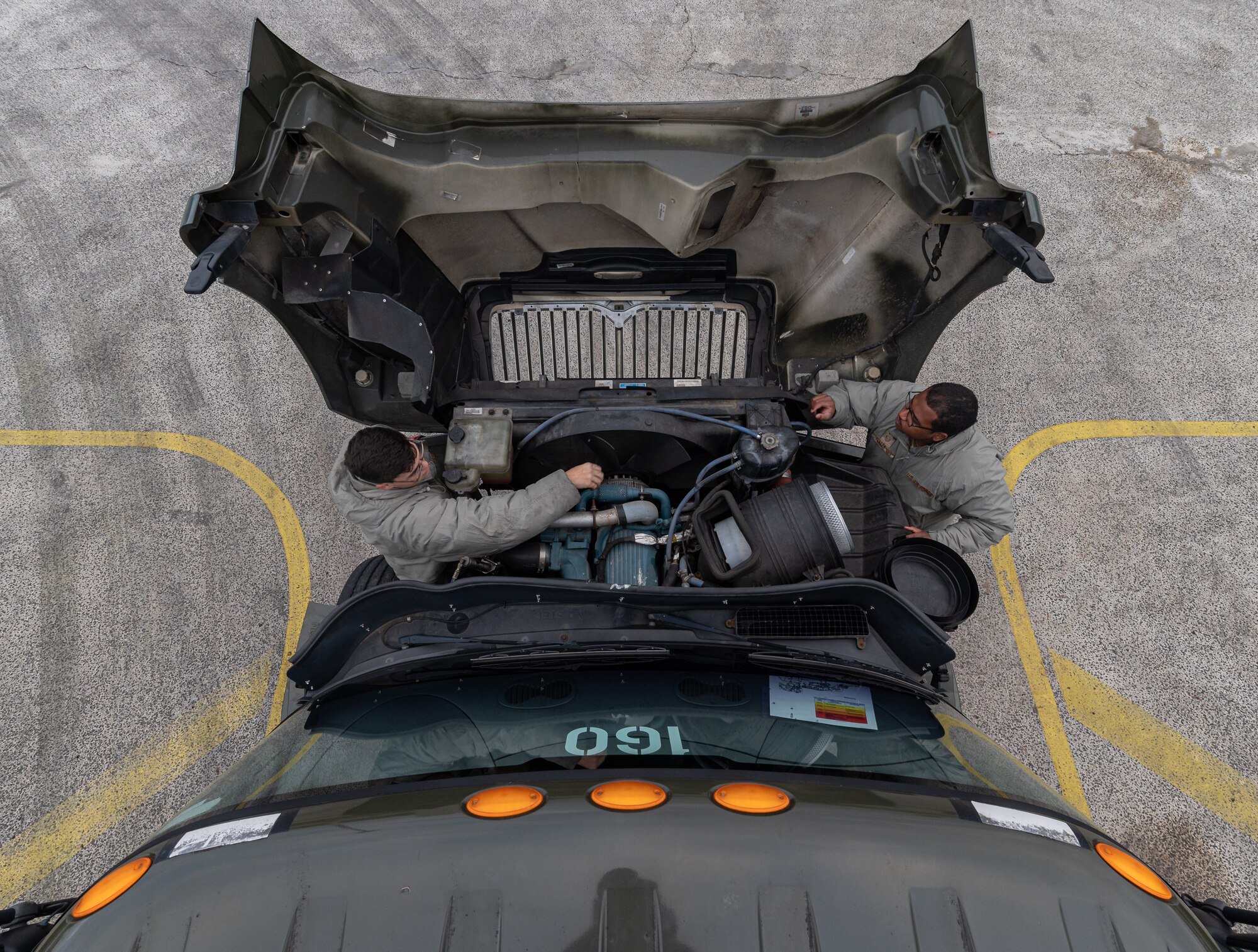 A top down view of Airmen checking an engine.