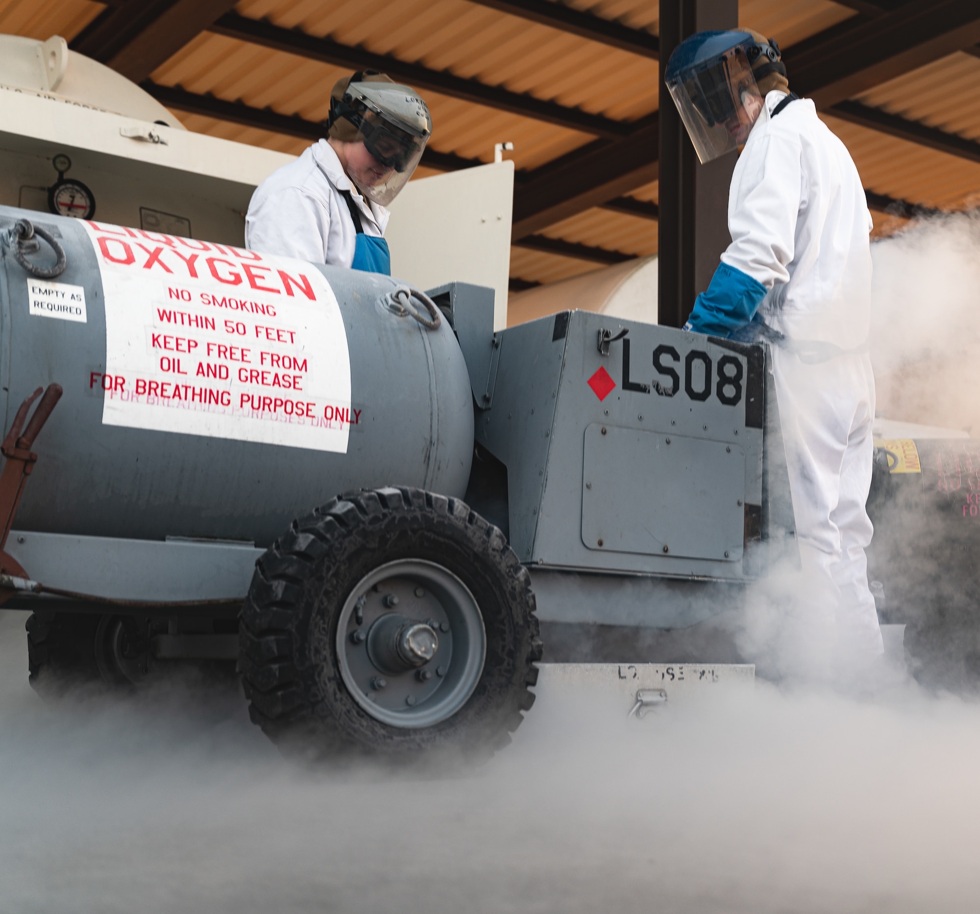 Airmen fill tank with oxygen