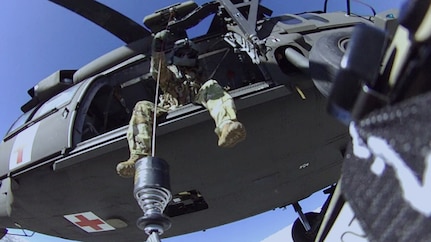 Tennessee National Guard Sgt. Chris Farrar lowers Sgt. 1st Class Tracy Banta, a critical care flight paramedic, to a stranded hiker on the Appalachian Trail Jan. 18, 2022. The Guard hoisted the hiker, who was suffering from hypothermia, to the helicopter and flew the patient to a hospital.