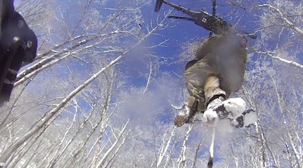 Tennessee National Guard Sgt. 1st Class Tracy Banta, a critical care flight paramedic, is hoisted to a UH-60 Black Hawk helicopter after rescuing a stranded hiker on the Appalachian Trail Jan. 18, 2022. The hiker was suffering from hypothermia.