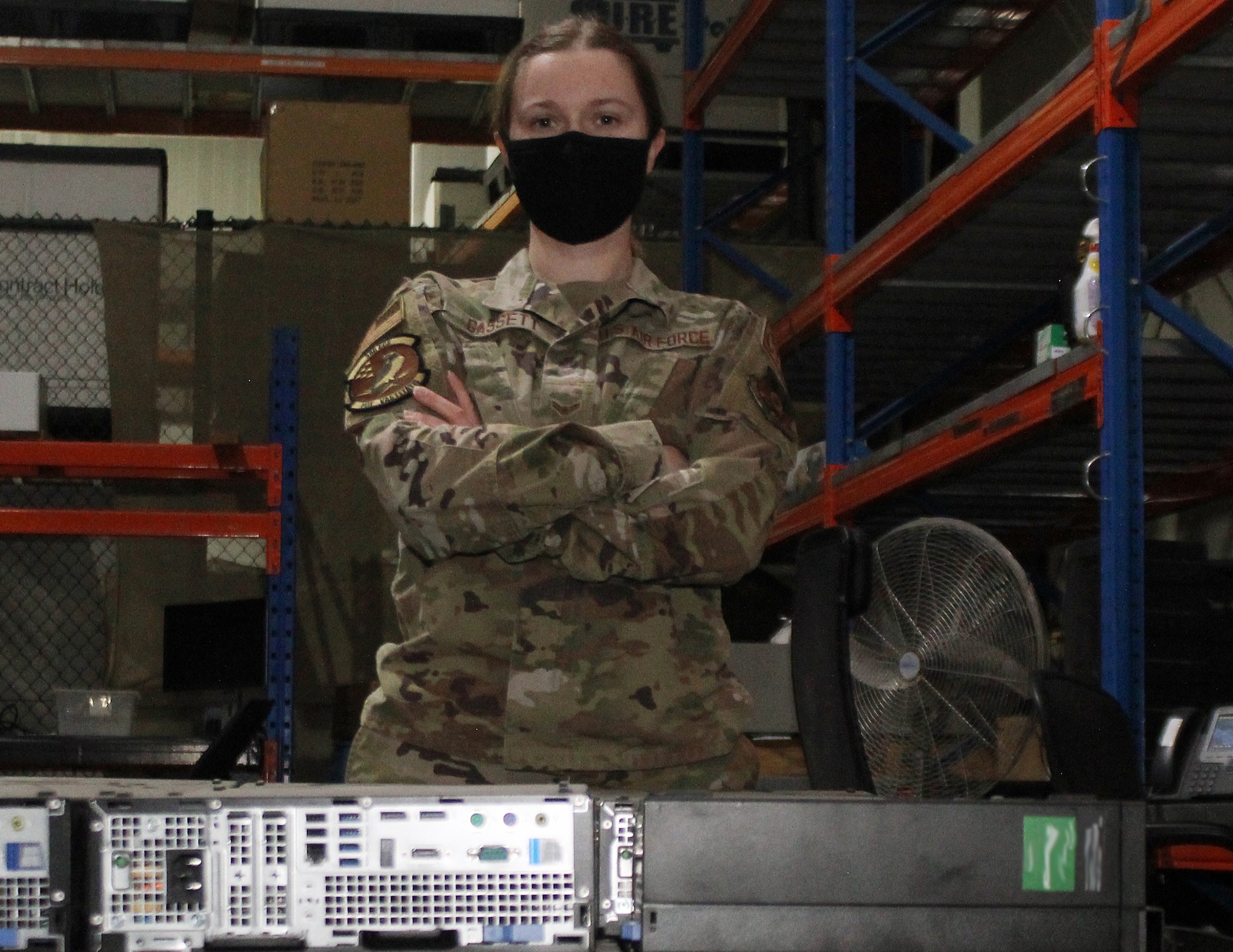 Airman 1st Class Hailey Gassett stands with old computer systems at the Base Equipment Control Office warehouse at Al Dhafra Air Base, Dec. 30, 2021. Gassett and the Airmen of the BECO shop are responsible for the inventory and, when necessary, disposal of all computer systems at the base. (U.S. Air Force photo by Master Sgt. Dan Heaton)