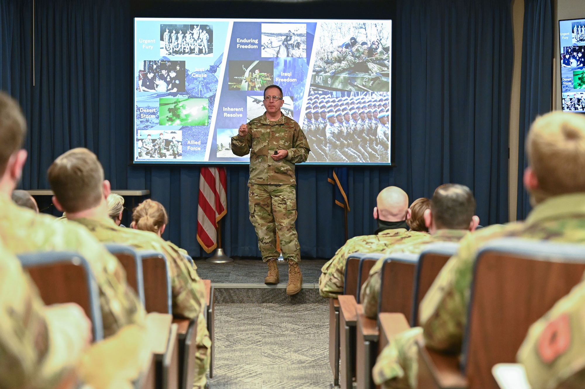 Man stands in front of audience.