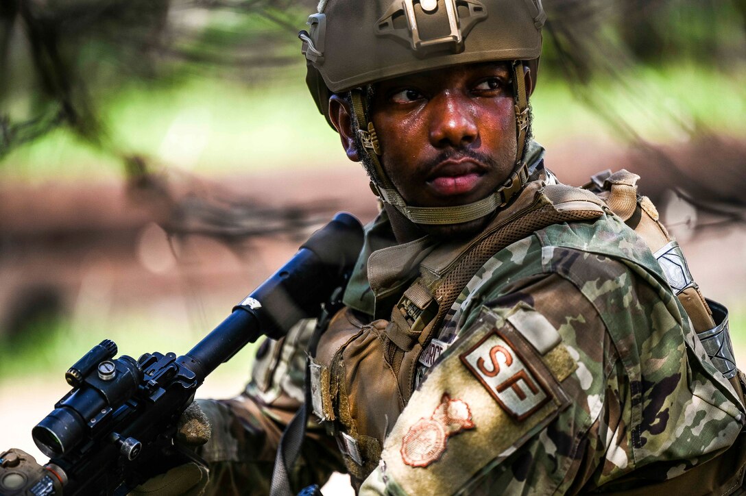 An airman holding a weapon looks around during training