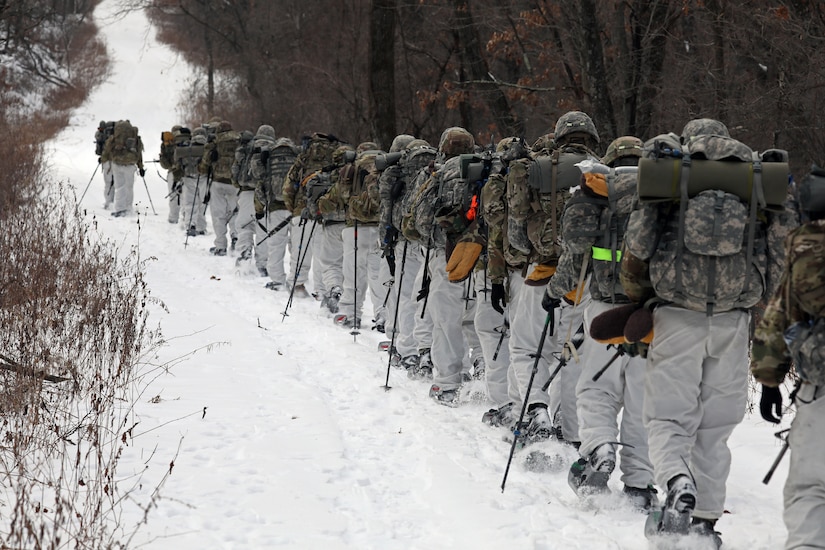 A group of cadets march in formation through the snow.
