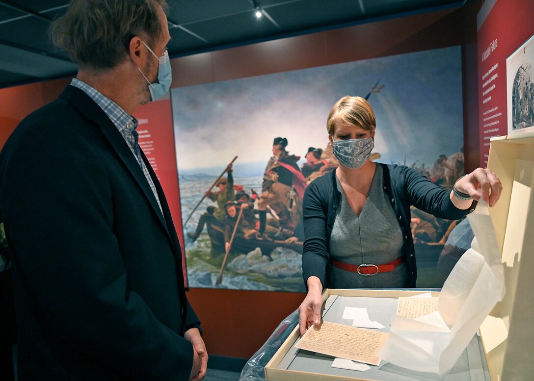 Image of a man and a woman in a museum focusing on an item.