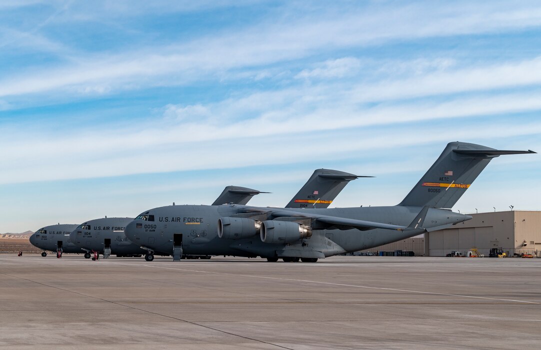 three large airplanes sit next to each other in a line