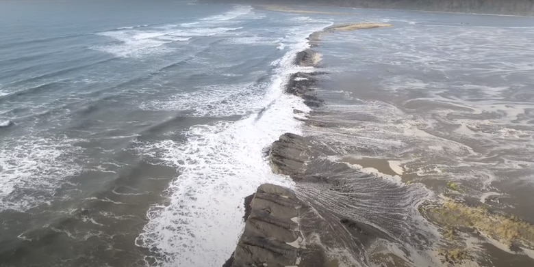 Overhead shot of waves hitting the berm during a storm