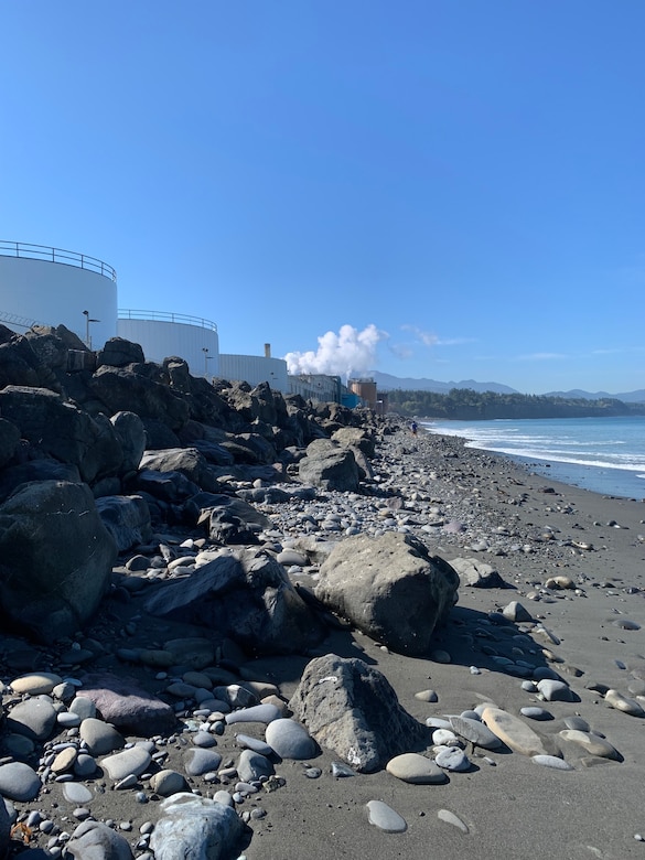 Photo facing west of the Ediz Hook revetment with industrial tanks in the background.