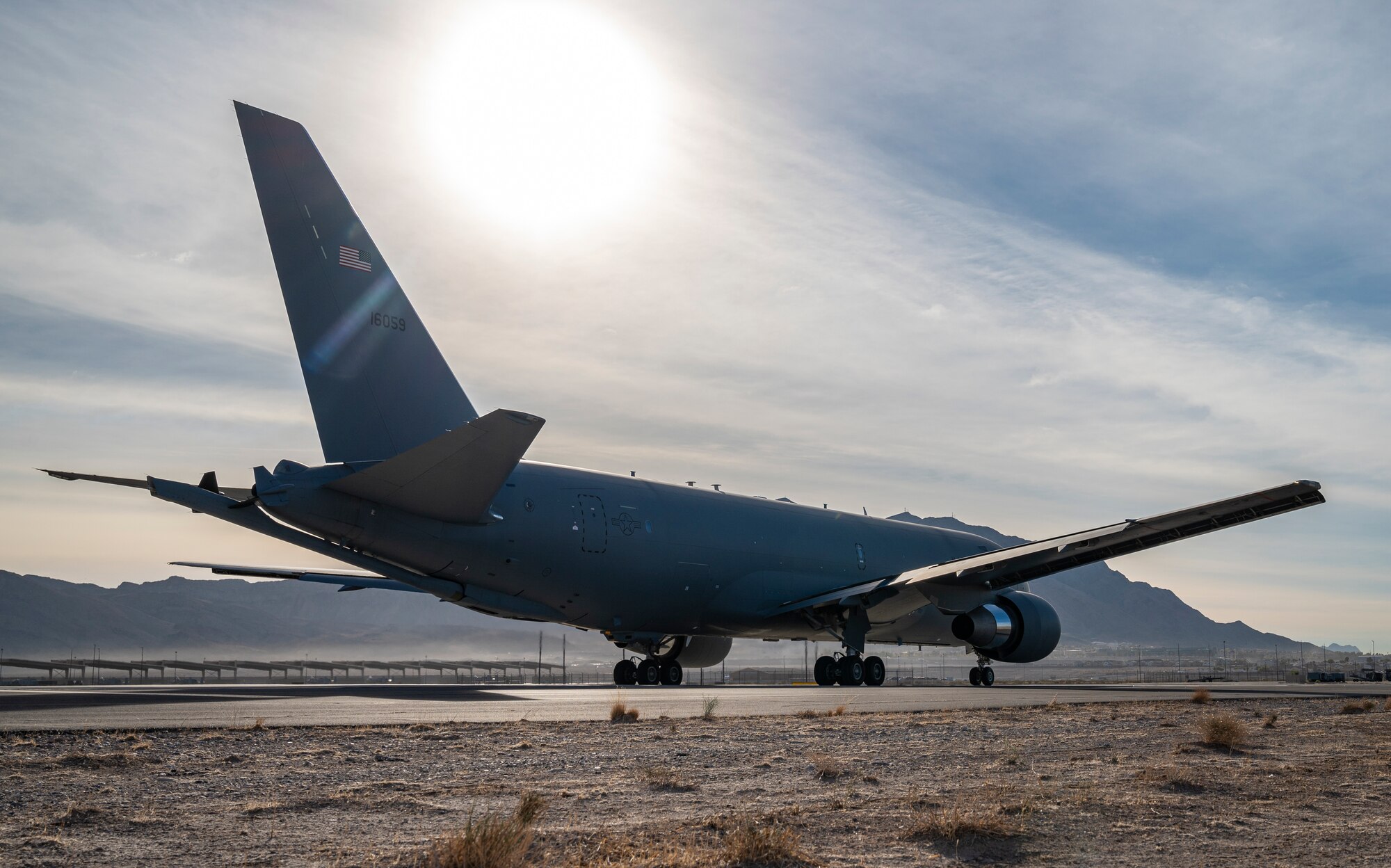 low angle shot of airplane on runway with sunset in background