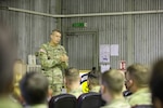 General speaks to a formation of service members in a National Guard armory.