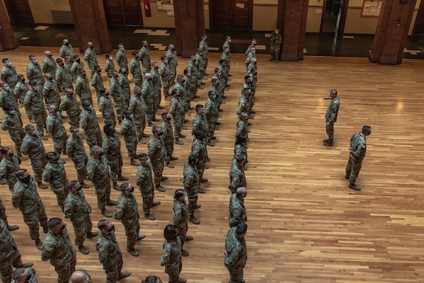 General speaks to a formation of service members in a National Guard armory.