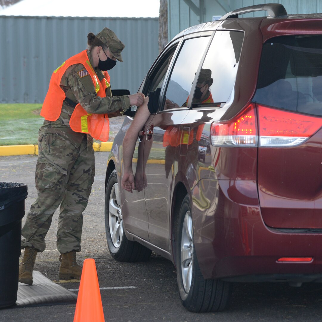 A National Guard medic administers a vaccination.