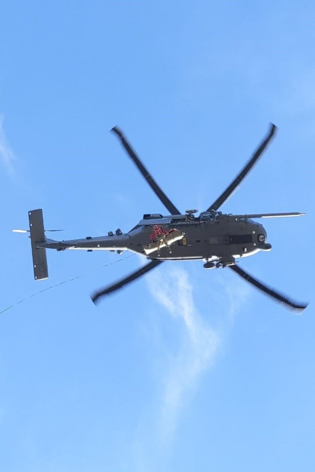 A helicopter is flying over a patient that is being rescued