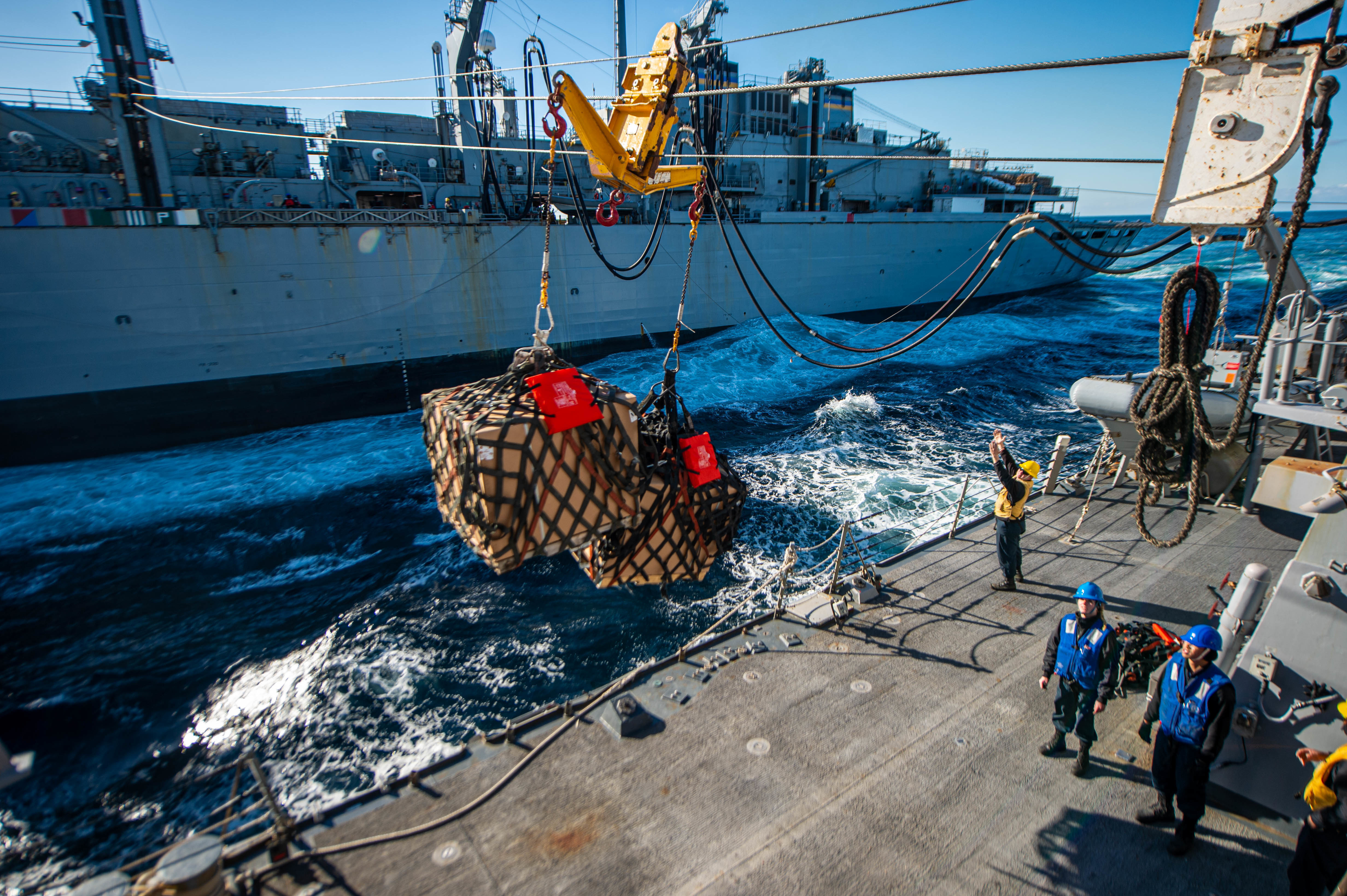 The Arleigh Burke-class guided-missile destroyer USS Jason Dunham (DDG 109) receives inventory from the Supply-class fast combat support ship USNS Supply (T-AOE-6) during a replenishment-at-sea.
